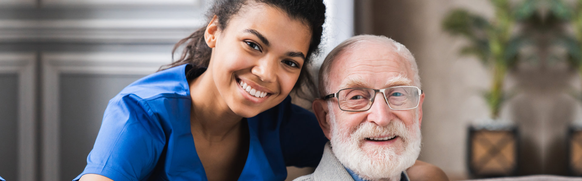caregiver and elder man smiling
